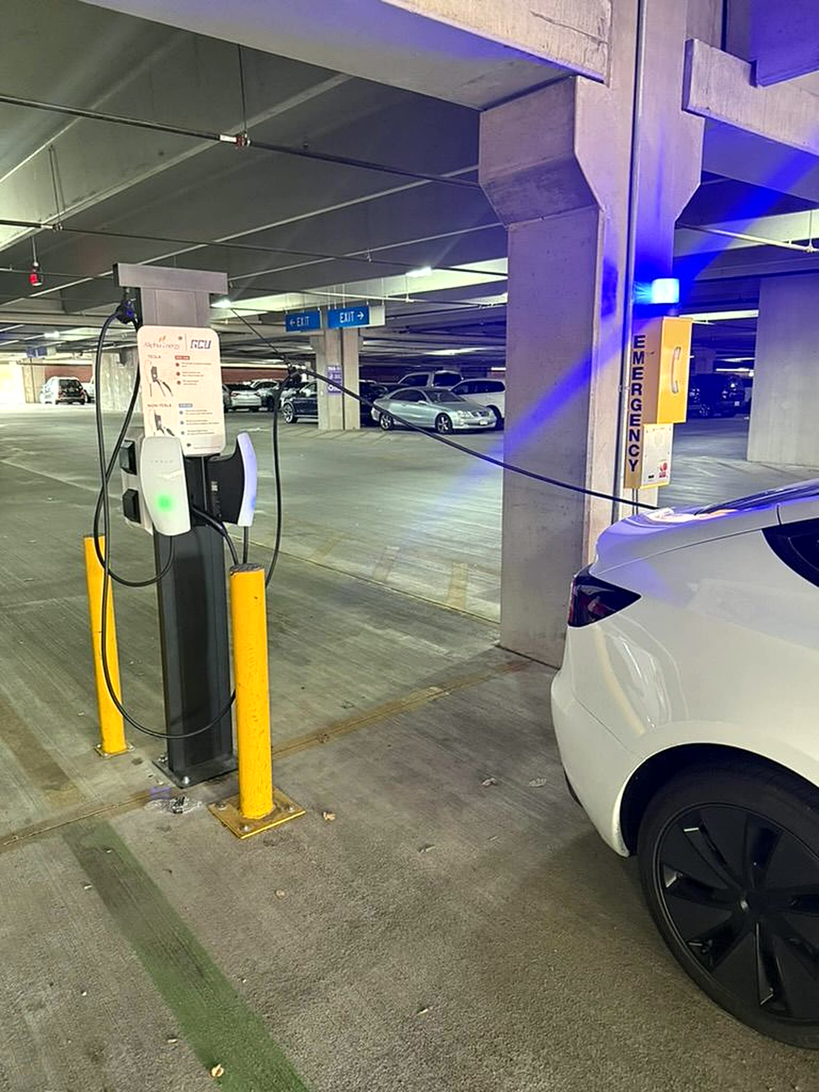 Aliphia Energy and GCU co-branded Level 2 charging pedestal with a Tesla plugged in